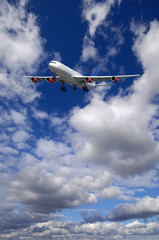 Wall Mural - Air travel - Plane is flying in blue sky with clouds