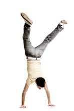 Young Adult Male Doing A Handstand On A White Background