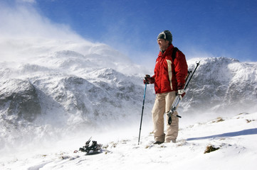 Pensive Man Standing Atop Snowy Mountain