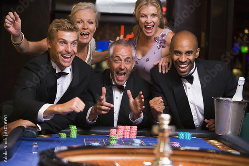 Fotografie, Obraz Five people in casino playing roulette smiling