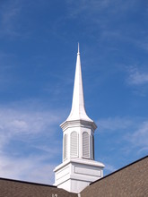 White Church Steeple With A Blue Sky Background