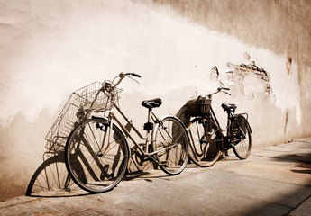 Fototapete - Italian old-style bicycles leaning against a wall 