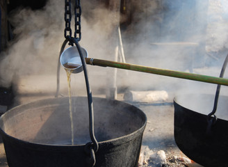 Wall Mural - making maple syrup by boiling the sap in a cauldron