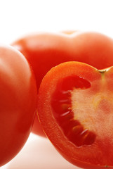 Wall Mural - close up shot of ripe juicy tomatoes over white