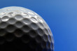 © zimmytws - Closeup of a golf ball, on blue background