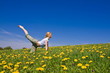 © kubais - young female excercising yoga on flowery meadow