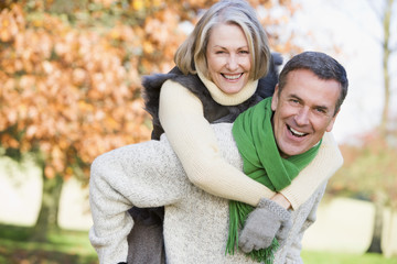 Senior man giving woman piggyback ride