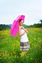 Happy Woman Outdoor On A Meadow With An Pink Umbrella