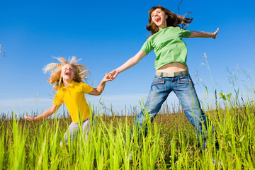 Wall Mural - Happy woman and girl making exercises on field.