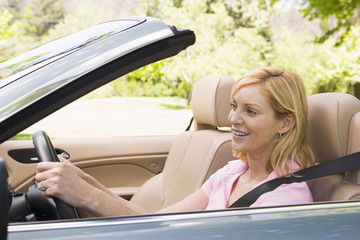 Wall Mural - Woman in convertible car smiling