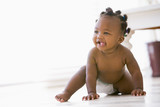 Fototapeta  - Baby crawling indoors smiling