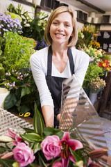 Wall Mural - Woman working at flower shop smiling