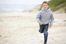 Young Boy Running On Beach Smiling
