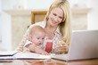 © Monkey Business - Mother and baby in dining room with laptop smiling