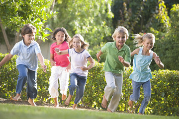 five young friends running outdoors smiling