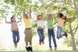 © Monkey Business - Five young friends jumping outdoors smiling