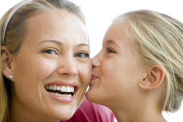 young girl kissing smiling woman