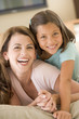 © Monkey Business - Woman and young girl in living room smiling