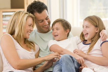 Family sitting in living room smiling