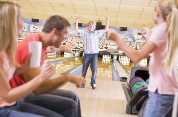 Wall Mural - Family in bowling alley cheering and smiling