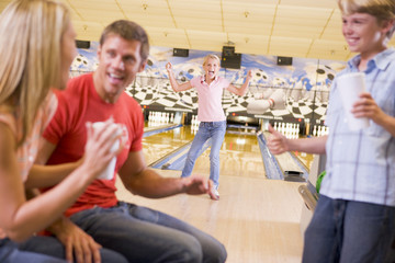 Wall Mural - Family in bowling alley cheering and smiling