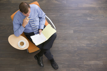 Wall Mural - Businessman sitting indoors with coffee and folder