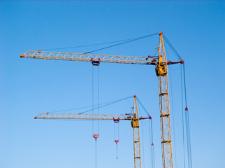 two tall yellow lifting cranes