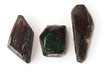 Three rough black matrix opals isolated on white, shallow dof.
