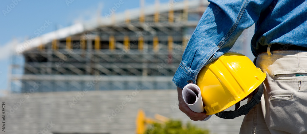 A construction worker or foreman at a construction site - obrazy, fototapety, plakaty 