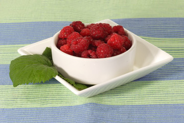 Frische Himbeeren mit Blatt in einer Schale