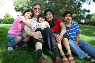 Large multiracial family sitting on lawn