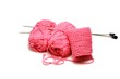 Pink yarn and needles on white bakcground.