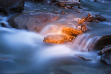 Blue River Stream At Night With Golden Light On Rocks