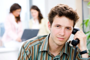 Wall Mural - Young businessman receiving phone calls at office