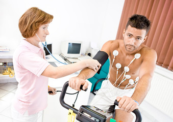 Nurse makes the patient ready for medical EKG test.