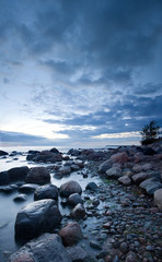 Mysterious view of stones and pebbles in water after sunset.