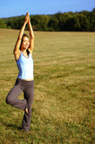 Fototapeta Las - Girl practicing yoga in a summer meadow.