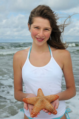 Teenaeger with starfish on the beach