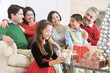 © Monkey Business - Family Sitting On Sofa In Front Of Christmas Presents