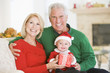 © Monkey Business - Grandparents With Baby In Santa Outfit
