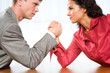 © pressmaster - Man and woman in arm wrestling gesture