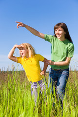 Wall Mural - Happy Woman and Girl on Field. Girl Surprised Something