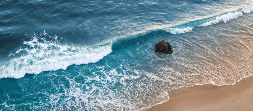 Fototapete - A wave breaking on a beach in central California.
