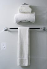 Three White Terry Cloth Towels On Towel Rack And Towel Holder