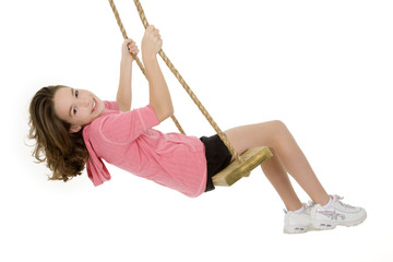 Caucasian child playing on a swing on white background