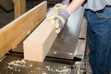 A carpenter  works on woodworking the machine tool.