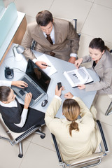 Canvas Print - Above view of working business group sitting at table