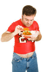 Wall Mural - Overweight middle aged man eating greasy chicken wings.