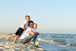 © Valua Vitaly - Young woman with two boys on the sand by the ocean.