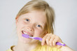 © Hallgerd - Little girl wearing colorful t-shirts brushing teeth